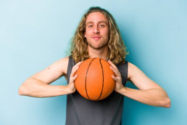 Beyazların basketbol oynayan genç adamı mavi arka planda izole edilmiş.