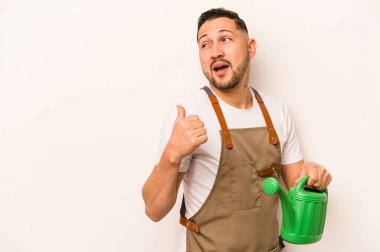 Bahçıvan İspanyol bir adam su dolu bir teneke kutu tutuyor. Beyaz arka planda, parmak uzakta, gülen ve kaygısız..