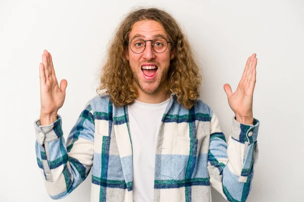 Beyaz arka planda izole genç beyaz adam hoş bir sürpriz alıyor, heyecanlı ve el kaldırıyor..