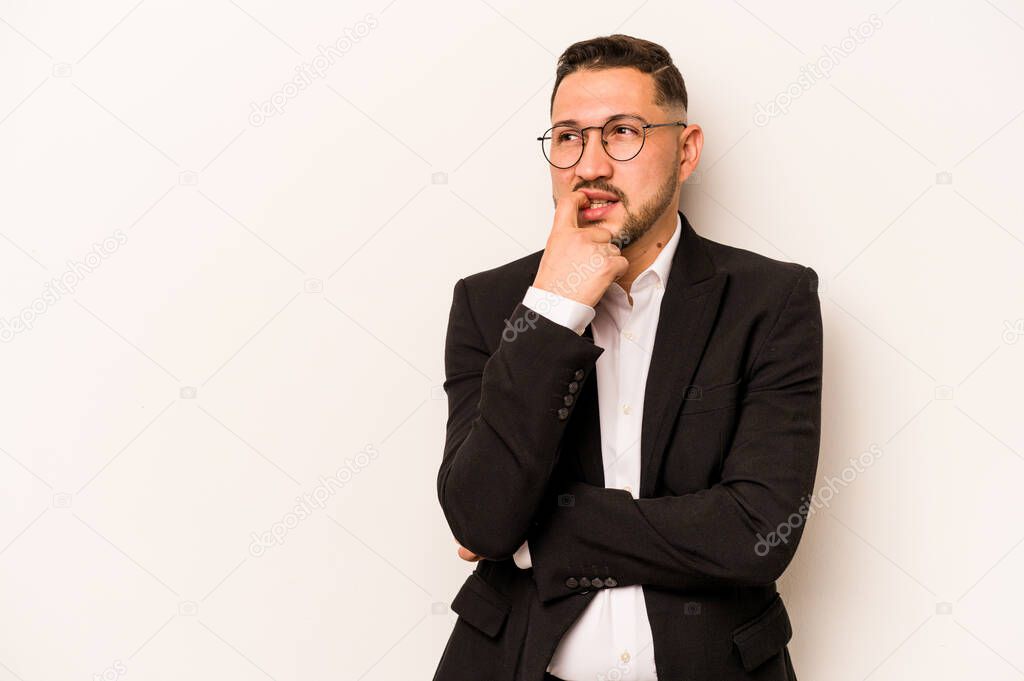 Business hispanic man isolated on white background relaxed thinking about something looking at a copy space.