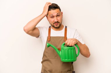 Bahçıvan İspanyol bir adam beyaz arka planda izole bir su bidonu tutuyor. Şok oluyor, önemli bir toplantıyı hatırlıyor..