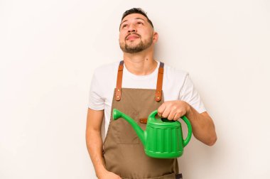 Bahçıvan İspanyol bir adam elinde su dolu bir teneke kutu ile beyaz arka planda hedeflerine ve amaçlarına ulaşmayı düşlüyor.