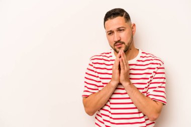 Latin kökenli genç bir adam beyaz arka planda izole edilmiş. Aklında bir plan kuruyor..