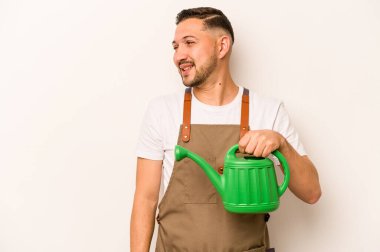 Bahçıvan İspanyol bir adam beyaz arka planda izole edilmiş bir su bidonu tutuyor. Gülümsüyor, neşeli ve keyifli..