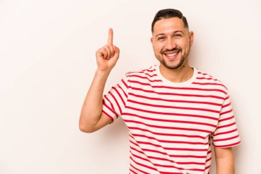 Beyaz arka planda izole edilmiş genç İspanyol bir numara parmağıyla görünüyor..