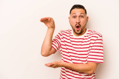 Beyaz arka planda izole edilmiş genç İspanyol adam elleri arasında bir kopya alanı tutarken şok ve hayrete düştü..