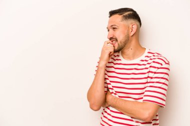 Beyaz arka planda izole edilmiş genç İspanyol bir adam rahatlamış bir şeyin fotokopi odasına baktığını düşünüyor..