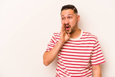 Beyaz arka planda izole edilmiş genç İspanyol bir adam gizli bir sıcak fren haberi veriyor ve yana bakıyor.