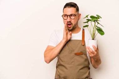 Beyaz arka planda izole edilmiş bir bitkiyi tutan İspanyol bahçıvan gizli bir sıcak fren haberinden bahsediyor.