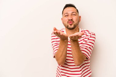 Beyaz arka planda izole edilmiş, dudakları kıvrılmış ve hava öpücüğü yollamak için avuç içi tutan İspanyol bir adam..