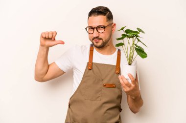 Beyaz arka planda izole edilmiş bir bitki tutan İspanyol bahçıvan kendini gururlu ve kendinden emin hissediyor..