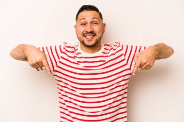 Beyaz arka planda izole edilmiş genç bir İspanyol. Parmakları aşağıda, olumlu hisler içinde..