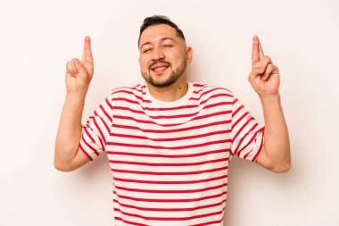 Latin kökenli genç bir adam beyaz arka planda izole edilmiş şans dilemek için şans diliyor.