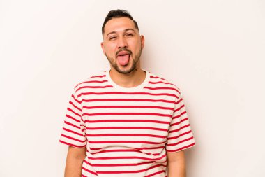 Beyaz arka planda izole edilmiş genç bir İspanyol komik ve dost canlısı bir dil uzatıyor..