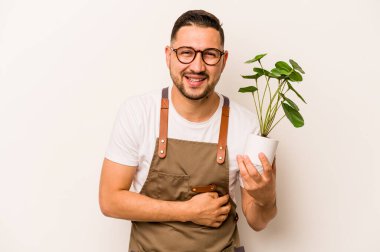 İspanyol bahçıvan elinde çiçekle beyaz arka planda gülüp eğleniyor..