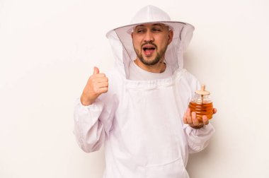 Beyaz arka planda bal tutan İspanyol arıcı parmak uzakta, gülen ve kaygısız..