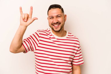 Beyaz arka planda izole edilmiş genç İspanyol bir adam boynuzlarını devrim konsepti olarak gösteriyor..