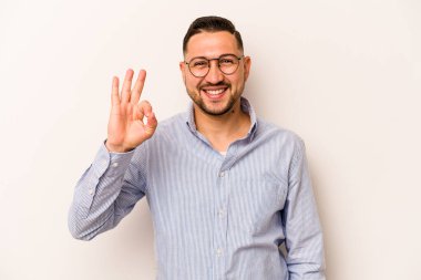 Genç İspanyol adam beyaz arka planda izole edilmiş neşeli ve kendinden emin, iyi bir jest yapıyor..