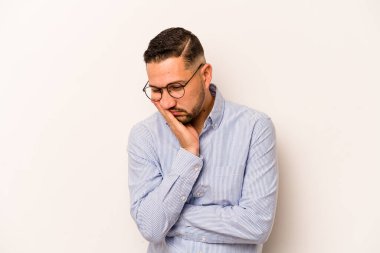 Beyaz arka planda izole edilmiş, sıkılmış, yorgun ve dinlenmeye ihtiyacı olan genç İspanyol bir adam..