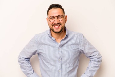 Beyaz arka planda izole edilmiş genç İspanyol bir adam. Kendine güveniyor. Kalçaları tutuyor..