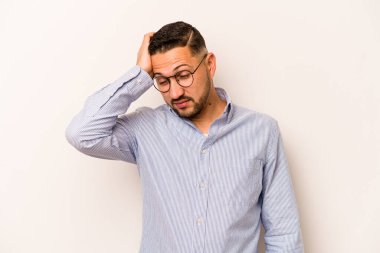 Beyaz arka planda izole edilmiş genç bir İspanyol. Çok yorgun ve uykulu. Elini başının üstünde tutuyor..