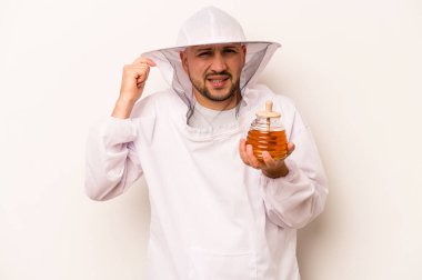 Beyaz arka planda izole edilmiş, elleri kulaklarında bal tutan İspanyol arı yetiştiricisi..