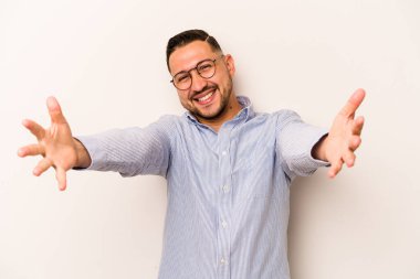 Beyaz arka planda izole edilmiş genç İspanyol adam kameraya sarıldığı için kendinden emin hissediyor..