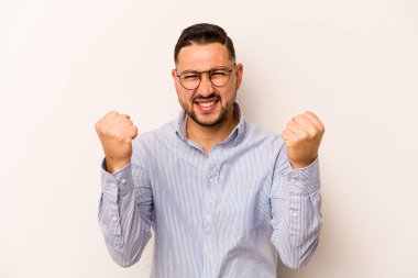 Beyaz arka planda izole edilmiş genç bir İspanyol tasasız ve heyecanlı bir şekilde tezahürat yapıyor. Zafer konsepti.