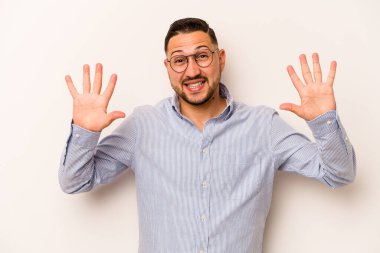 Beyaz arka planda izole edilmiş genç İspanyol adam on numarayı elleriyle gösteriyor..