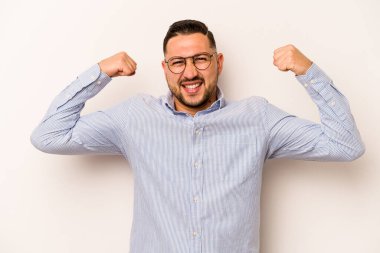 Beyaz arka planda izole edilmiş genç bir İspanyol kadın gücünün sembolü olan kollarıyla güçlü bir hareket sergiliyor.