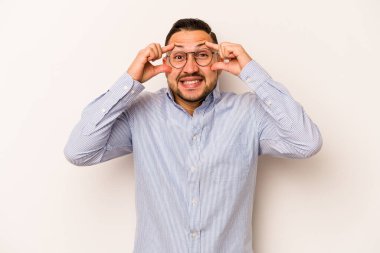 Beyaz arka planda izole edilmiş genç bir İspanyol başarılı bir fırsat yakalamak için gözlerini açık tutuyor..