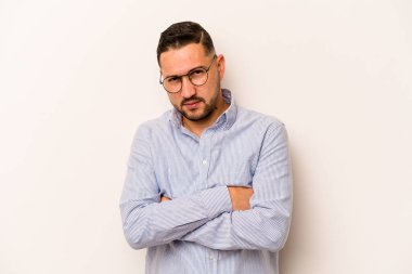 Beyaz arka planda izole edilmiş genç İspanyol adam alaycı bir ifadeyle kameraya bakıyor..
