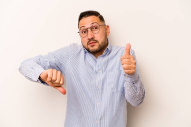 Beyaz arka planda izole edilmiş genç bir İspanyol, baş parmağını kaldırıyor, zor bir seçim.