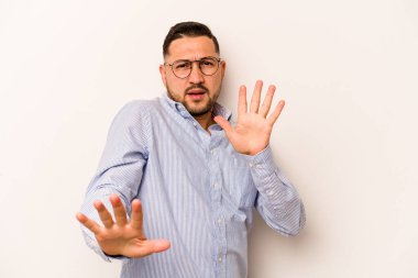 Beyaz arka planda izole edilmiş genç bir İspanyol, yakın bir tehlike nedeniyle şok oluyor.