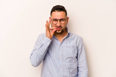 Beyaz arka planda izole edilmiş genç İspanyol adam parmakları dudaklarında bir sır saklıyor..