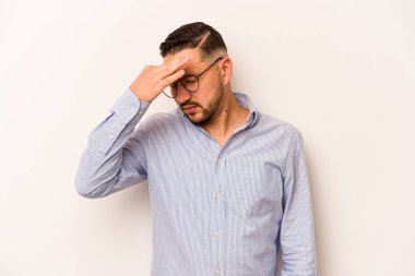 Beyaz arka planda izole edilmiş genç İspanyol bir adamın başı ağrıyor, yüzüne dokunuyor..