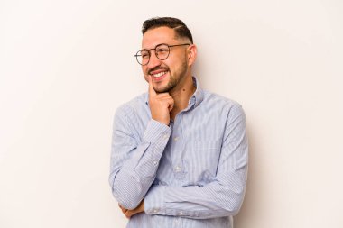 Latin kökenli genç bir adam beyaz arka planda izole edilmiş. Bir strateji planlıyor, bir iş yolu düşünüyor..