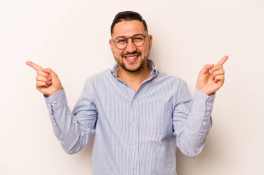 Beyaz arka planda izole edilmiş genç İspanyol adam farklı kopya alanlarını gösteriyor, birini seçiyor, parmaklarıyla gösteriyor..