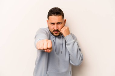 Latin kökenli genç bir adam beyaz arka planda izole edilmiş. Yumruk atıyor, sinirleniyor, kavga ediyor..