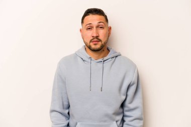 Genç İspanyol adam beyaz arka planda izole edilmiş üzgün, ciddi yüzlü, mutsuz ve hoşnutsuz..