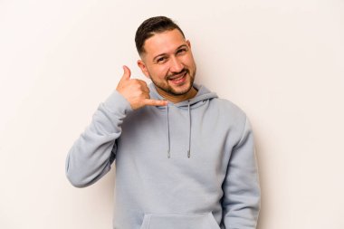 Beyaz arka planda izole edilmiş genç bir İspanyol, parmakları olan bir cep telefonu hareketi gösteriyor..