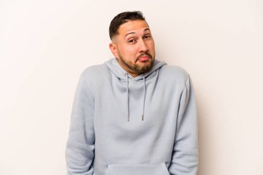 Beyaz arka planda izole edilmiş genç bir İspanyol omuz silkiyor ve gözleri açık..