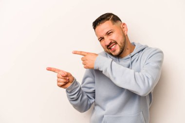 Beyaz arka planda izole edilmiş genç bir İspanyol işaret parmaklarıyla işaret ederek heyecanlanıyor..