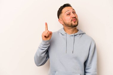 Beyaz arka planda izole edilmiş genç İspanyol bir numara parmağıyla görünüyor..