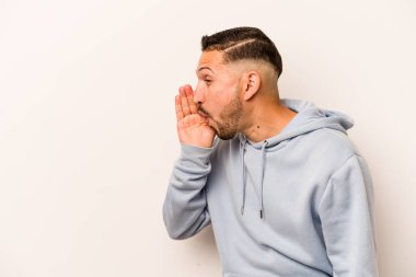 Beyaz arka planda izole edilmiş genç İspanyol bir adam gizli bir sıcak fren haberi veriyor ve yana bakıyor.