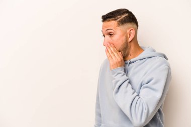 Beyaz arka planda izole edilmiş genç İspanyol adam gördüğü bir şey yüzünden şoka uğruyor..