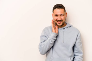 Beyaz arka planda izole edilmiş genç bir İspanyol yüksek sesle bağırıyor, gözleri açık ve elleri gergin tutuyor..