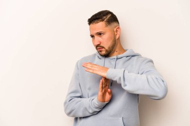 Beyaz arka planda izole edilmiş genç İspanyol bir adam bir mola hareketi gösteriyor..