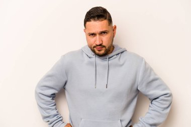 Beyaz arka planda izole edilmiş genç bir İspanyol kafası karışmış, kuşkulu ve güvensiz hissediyor..