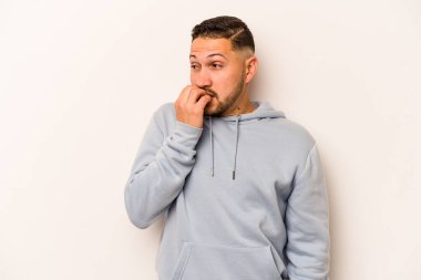 Beyaz arka planda izole edilmiş, tırnak yiyen, gergin ve endişeli genç bir adam..